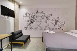 1 dormitorio con 1 cama y un dibujo en la pared en athensdot en Atenas