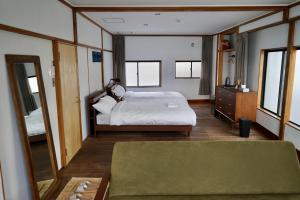 een slaapkamer met een bed en een grote spiegel bij Tagore Harbor Hostel in Numazu