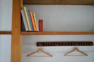 un estante de libros con algunos libros. en Tagore Harbor Hostel, en Numazu