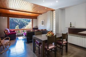 L'Adó في ريبول: غرفة طعام مع طاولة وأريكة