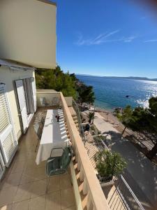 uma varanda com uma mesa e cadeiras e o oceano em Brela Beachfront em Brela