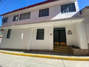 un edificio blanco con puertas negras en una calle en Tupac Huaraz, en Huaraz