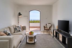 a living room with a couch and a tv at Casa Limón in Nerja