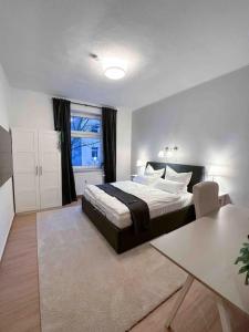 a bedroom with a large bed and a window at Modern City apt. -with 2 TV, Netflix and work desk in Essen