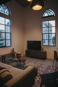 a living room with a couch and a flat screen tv at Beautiful Bohemia apt in Jaffa in Tel Aviv