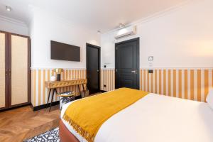 a bedroom with a bed and a tv on the wall at DH Rooms Spiga in Milan