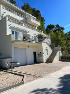 a large white house with a garage and stairs at Brela Beachfront in Brela