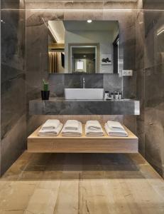 bagno con bancone, lavandino e specchio di Porto Greco Village Beach Hotel a Hersonissos