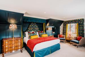 a bedroom with a large bed with a red bedspread at Hever Castle Luxury Bed and Breakfast in Edenbridge