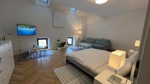 a bedroom with a bed and a living room with a couch at Franco Apartments in Kežmarok