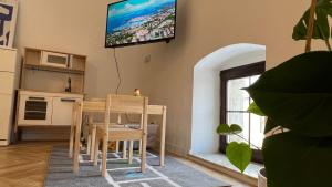 a living room with a table and a television on the wall at Franco Apartments in Kežmarok