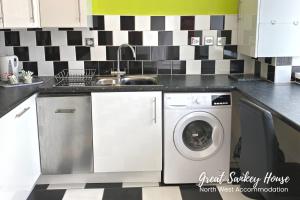 a kitchen with a sink and a washing machine at Great Sankey Serviced Accommodation in Warrington
