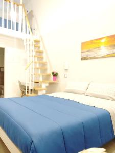 un letto con coperta blu in una camera da letto di Casa Al Massimo a Palermo