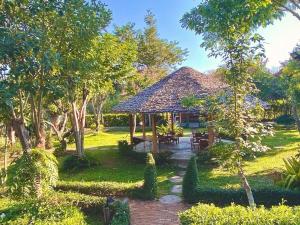 einen Pavillon mit einem Tisch und Stühlen im Garten in der Unterkunft Kirina in Pai