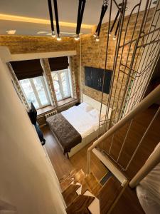 a small bedroom with a bed and a staircase at Kyiv Whisky Box Apartments in Kyiv