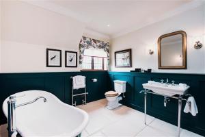 a bathroom with a tub and a toilet and a sink at Hever Castle Luxury Bed and Breakfast in Edenbridge