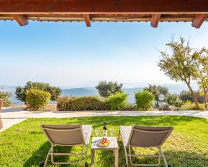 a patio with two chairs and a table with a bottle of wine at Amirey Hagalil Boutique Hotel in Amirim