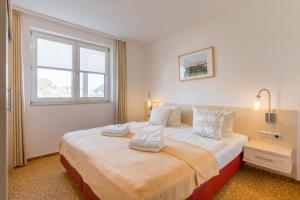 ein Schlafzimmer mit einem großen Bett mit zwei Handtüchern darauf in der Unterkunft 2 Ferienwohnung Ostseeperle Komfort in Zingst