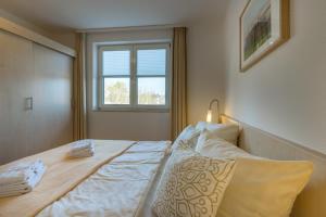 Schlafzimmer mit einem großen Bett und einem Fenster in der Unterkunft 2 Ferienwohnung Ostseeperle Komfort in Zingst