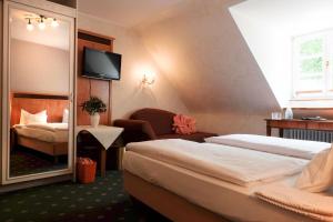 a hotel room with two beds and a mirror at Hotel Molitors Mühle in Eisenschmitt