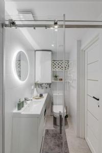 La salle de bains blanche est pourvue d'un lavabo et de toilettes. dans l'établissement Modern & Light Loft close to City Center, à Vilnius