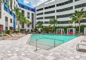 a swimming pool in the courtyard of a building at Lovely Doral 2BR Pool Gym MIA-16 in Miami