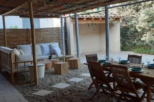 un patio con sofá, mesa y sillas en Magnifique coin de mas avec piscine privative, en Meynes