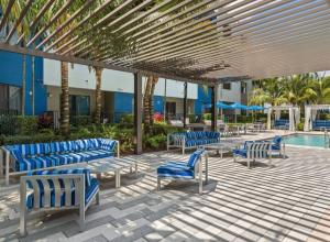 a patio with blue chairs and a swimming pool at Lovely Doral 2BR Pool Gym MIA-16 in Miami