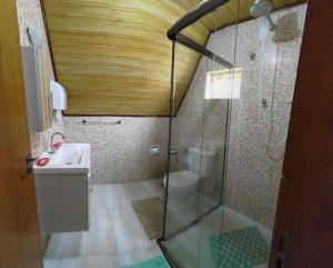 a bathroom with a shower with a toilet and a sink at Pousada Florada da Serra in Monte Verde