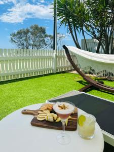 a drink and a plate of food on a table at Tessa's on the Beach in Gold Coast