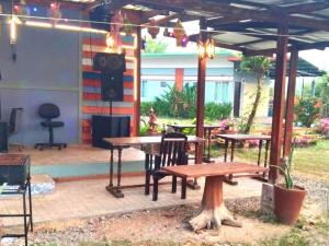 a patio with two picnic tables and a speaker at บ้านสวนสุขใจ รีสอร์ท in Ban Makok