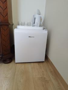 a white refrigerator with glasses on top of it at Eglutė in Šilutė