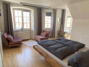 una camera con un grande letto e due sedie di Room in Apartment - Schlafen Wie Prinzessinnen In Kemptens Schlosschen a Kempten