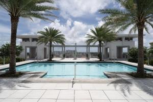 a swimming pool with palm trees in front of a building at Coral Gables 1br w wd pool gym near shops MIA-53 in Miami