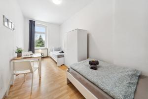 a bedroom with a bed and a table and a desk at Gemütliche Apartments im Herzen von Halle in Halle an der Saale