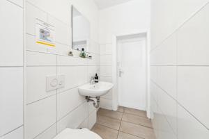 a white bathroom with a toilet and a sink at Gemütliche Apartments im Herzen von Halle in Halle an der Saale