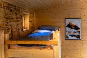 um quarto com uma cama num chalé de madeira em Tiny House nad Českým rájem em Všelibice
