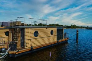 巴特Hausboot Fjord POLARIS mit Biosauna in Barth的木船停靠在水中