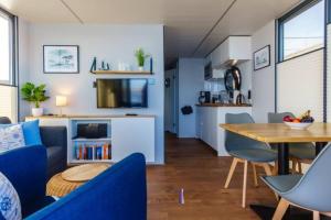 uma sala de estar com um sofá azul e uma mesa em Hausboot Fjord POLARIS mit Biosauna in Barth em Barth