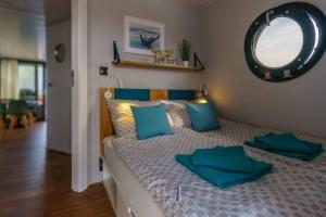 1 dormitorio con cama con almohadas azules y espejo en Hausboot Fjord POLARIS mit Biosauna in Barth en Barth