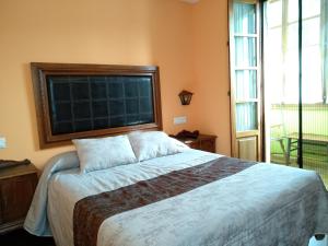 1 dormitorio con cama grande y ventana grande en Hotel Casa Vieja del Sastre, en Soto de Luiña