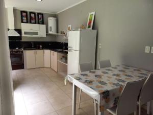 羅克薩恩斯培尼亞總統城的住宿－CBH Alquiler Temporario，厨房配有桌子和白色冰箱。