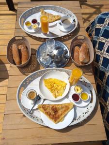 een tafel met drie borden ontbijtproducten erop bij Santacruz Hostel in Tamraght Ouzdar