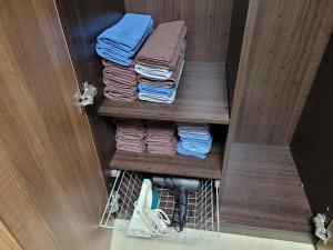 a group of folded towels in a closet at SinNaMu Family House in Suwon +37 photos