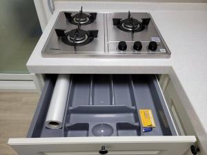 a stove top oven in a drawer in a kitchen at SinNaMu Family House in Suwon