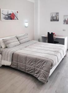 een witte slaapkamer met een groot bed en een bureau bij Casa Al Massimo in Palermo