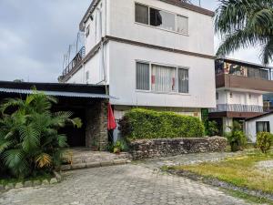 Biały budynek z palmą przed nim w obiekcie Gantavya Resort w mieście Pokhara