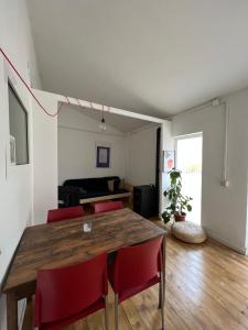 une salle à manger avec une table en bois et des chaises rouges dans l'établissement Precioso apartamento en el centro de Esparreguera, à Esparraguera