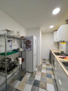 cocina con nevera y suelo a cuadros en Precioso apartamento en el centro de Esparreguera, en Esparreguera