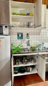 uma cozinha com um lavatório e algumas panelas e frigideiras em Casinha na Ilha do Mel - Pr na Ilha do Mel